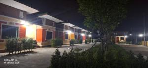 une rangée de maisons la nuit avec des lumières dans l'établissement S&P Resort บ้านบุใหญ่ ตำบลสูงเนิน อำเภอสูงเนิน, à Ban Sukhawadi