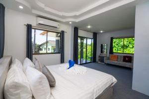 a bedroom with a large white bed with pillows at 3 Bed 3 Bath Villa 400m to Beach in Ban Lum Fuang