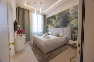 a bedroom with a bed and a painting on the wall at Hotel Belvedere in Forte dei Marmi