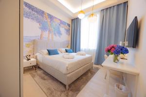 a bedroom with a bed and a desk with flowers on it at Hotel Belvedere in Forte dei Marmi
