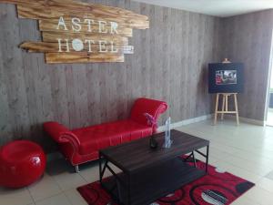 a living room with a red couch and a table at Aster+ Hotel Bukit Jalil in Kuala Lumpur +48 photos