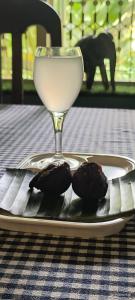 a table with a plate of food and a wine glass at White Butterfly -A Countryside Farmstay in Trivandrum