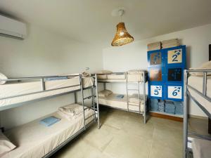 Una habitación con tres literas y una luz. en Adriatic Hostel Vlora, en Vlorë