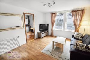 a living room with a couch and a tv at Thistle Apartments - Marischal Square in Aberdeen