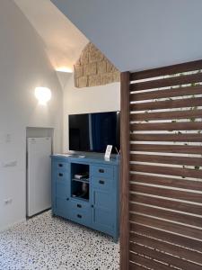 a room with a blue cabinet and a television at Guest House Signature in Bacoli