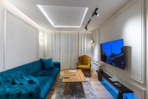 ein Wohnzimmer mit einem blauen Sofa und einem Tisch in der Unterkunft The Luxury Loft in Bascarsija with free parking in Sarajevo