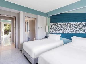 two beds in a hotel room with blue walls at Rixos Premium Tekirova - The Land of Legends Access in Tekirova