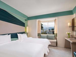 a bedroom with two white beds and a window at Rixos Premium Tekirova - The Land of Legends Access in Tekirova