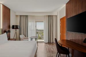 亚的斯亚贝巴Doubletree By Hilton Addis Ababa Airport的配有床、书桌和电视的酒店房间 更多37张照片