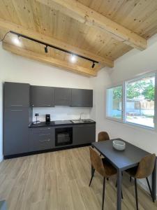 a kitchen with black cabinets and a table and chairs at VILLA AMBROSIA 172 A in Terracina