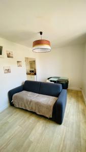 a living room with a blue couch in a room at Le coin détente in Nevers