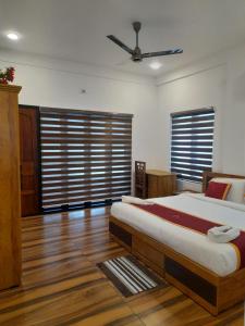 a bedroom with a bed and a ceiling fan at VGK Residency in Wayanad