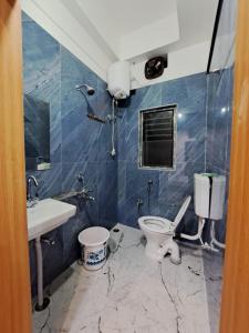 a bathroom with a toilet and a sink at Uttam Hotel & Restaurant in Guwahati