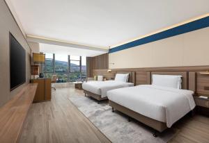 TianshuiにあるDays Hotel by Wyndham Tianshui Qinzhouのベッド2台と薄型テレビ付きのホテルの部屋 +10枚の写真