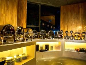 a kitchen with plates and utensils on a shelf at Atour Hotel Canal Hangzhou in Hangzhou