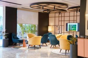 a waiting room with chairs and a table and a tv at Ramada Encore by Wyndham Chandigarh Zirakpur in Zirakpur