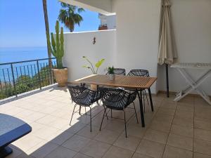a table and chairs on a balcony with the ocean at El sol Espanol in Torrox Costa