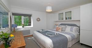 a bedroom with a bed and a table at 7 Porth Valley Cottage's in Newquay