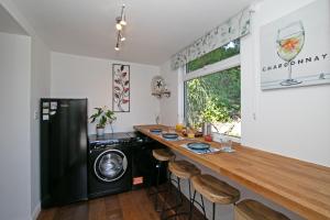 a kitchen with a counter with a washer and dryer at 7 Porth Valley Cottage's in Newquay