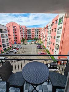 a balcony with a table and chairs and buildings at Traveler's Nest near Airport, Netflix, Stylish, Cozy with swimming pool in Lapu Lapu City +18 photos