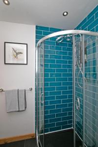 a bathroom with blue tiles and a shower at 7 Porth Valley Cottage's in Newquay +23 photos