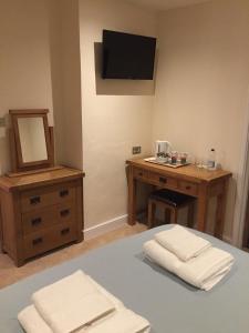 a bedroom with a bed with a desk and a mirror at Bryn Derwen in Rhayader
