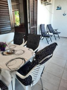 a table and chairs in a room with a table at Apartman Marinamar in Utjeha