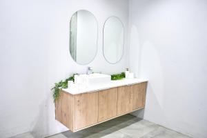a bathroom with a sink and two mirrors at Paradise Bay- Luxury Apartment in La Mercy