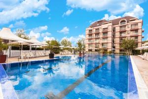 a large swimming pool in front of a hotel at All-inclusive Holiday Apartments in Tarsis Hotel & Aquapark in Sunny Beach