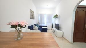 a living room with a blue couch and a vase of flowers at La Abundancia in La Restinga