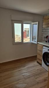 a kitchen with three windows and a washing machine at Apartamentos Pino in Benidorm