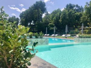 a swimming pool with umbrellas and chairs at Santoro Country House Boutique Etna Retreat in Castiglione di Sicilia