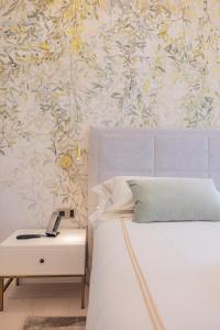 a bedroom with a bed and a table with a phone at Hotel Belvedere in Forte dei Marmi