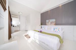 a white bedroom with a large bed with flowers on it at Laguna Townhouse with private pool and your own gym near Bangtao Beach in Laguna Phuket +6 photos