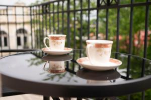 zwei Kaffeetassen auf einem Glastisch in der Unterkunft Willa Matejki - Apartament 8b in Przemyśl