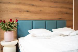 zwei Betten in einem Zimmer mit einer Vase mit roten Rosen in der Unterkunft Willa Matejki - Apartament 8b in Przemyśl