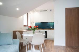 ein Wohnzimmer und eine Küche mit einem Tisch und Stühlen in der Unterkunft Willa Matejki - Apartament 8b in Przemyśl