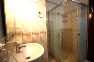 a bathroom with a sink and a glass shower at Bonapart Hotel in Çeşme +128 photos