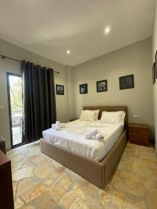 a bedroom with a large bed in a room at Atlantid Hospitality Hotel in Qeparo