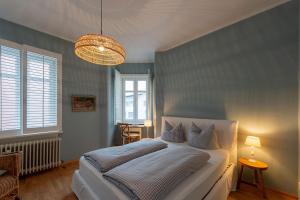 a bedroom with a white bed and a chandelier at Strömbergs Merle in Oberstaufen