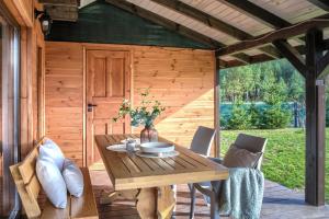 a wooden table and chairs on a patio at Domki Omulew in Wikno
