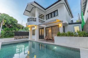a house with a swimming pool in front of it at Luxury Pool Villa Jomtien-1 Min to Beach in Jomtien Beach