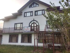 Casa blanca con ventanas y balcón en Highway Heaven, en Srinagar