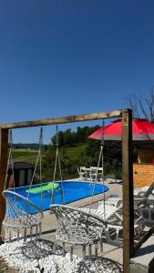 a swing yard with a pool and a table at Vikendica Brvnara Marčetić in Banja Luka