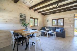 a living room with a table and a couch at Domki Omulew in Wikno