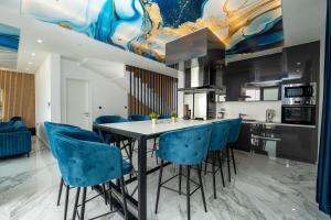 a kitchen with a table and blue chairs at Villa Dubai in Novalja
