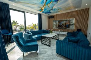 a living room with blue couches and a painting on the ceiling at Villa Dubai in Novalja