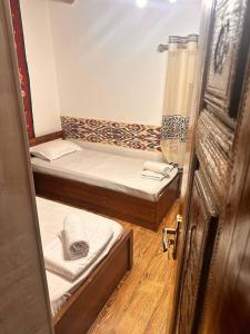 une paire de lits dans une petite pièce dans l'établissement Ohun saray Historical Museum hotel XIX century Best cheap in old sity Bukhara boasts a wealth of historical monuments, reflecting its rich history as a major Silk Road city, à Boukhara