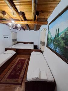 une chambre avec deux lits et un tableau au mur dans l'établissement Ohun saray Historical Museum hotel XIX century Best cheap in old sity Bukhara boasts a wealth of historical monuments, reflecting its rich history as a major Silk Road city, à Boukhara 62 autres photos