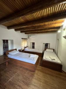 Cette chambre spacieuse dispose de 2 lits et de parquet. dans l'établissement Ohun saray Historical Museum hotel XIX century Best cheap in old sity Bukhara boasts a wealth of historical monuments, reflecting its rich history as a major Silk Road city, à Boukhara